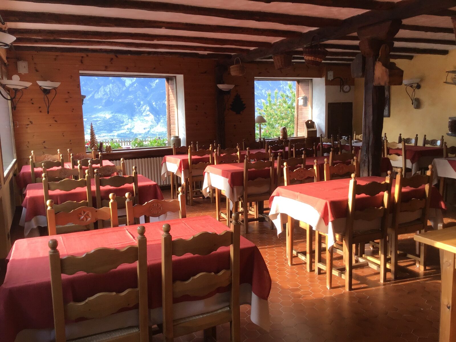 Salle commune de l'Auberge Le Rochasson — chalet en bois, tables dressées et vue sur les montagnes