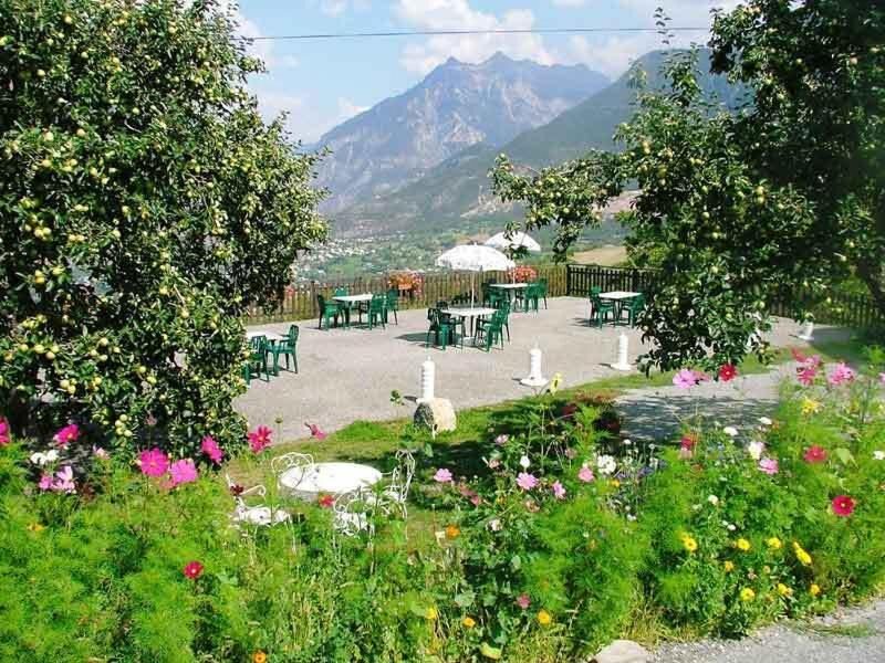 Terrasse extérieure de l'Auberge Le Rochasson — jardin fleuri et vue panoramique sur la vallée